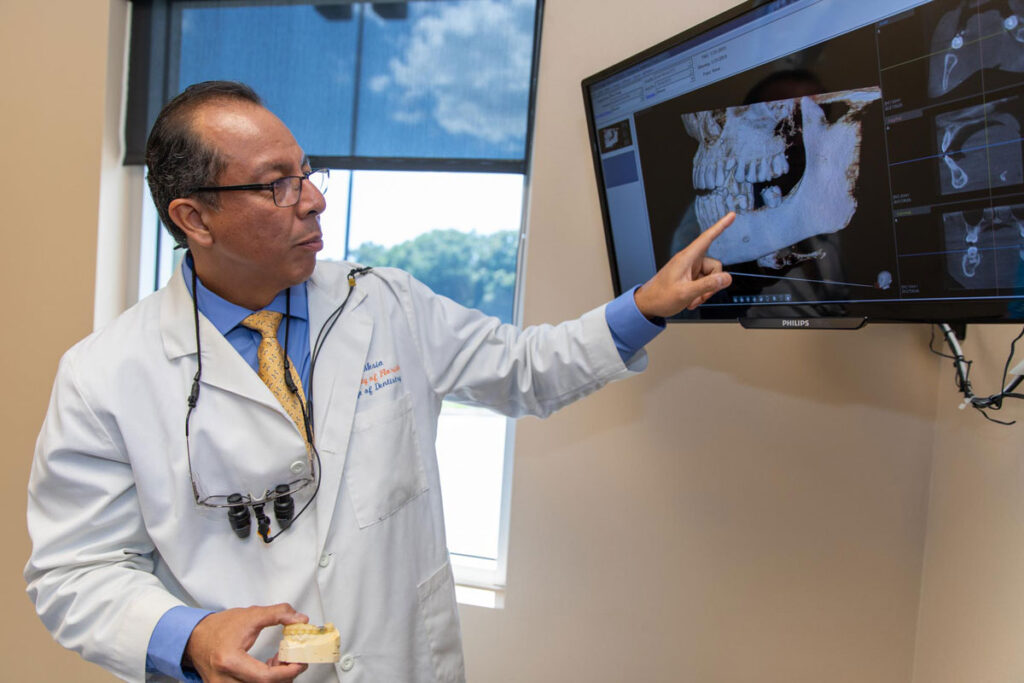 Dr Mesia Pointing At Dental Implant Patient XRay